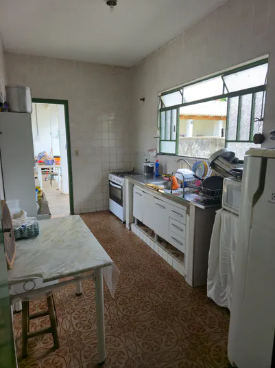 Cozinha completa e equipada da moradia estudantil com eletrodomésticos e armários organizados