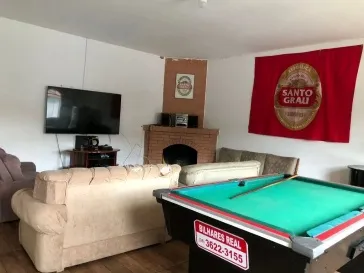 Sala de estar da República Santo Grau com TV 4K e sofás confortáveis para lazer dos estudantes